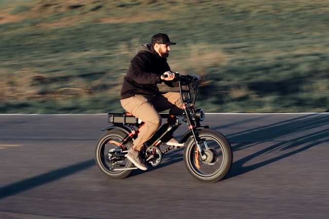 Man riding an e-bike down a street